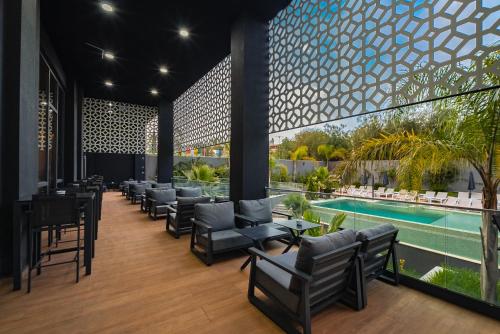 a hotel lobby with chairs and a pool at AD HOTEL HYDRA in Alger