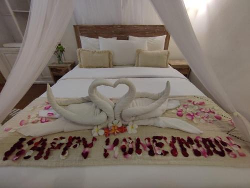 two swans making a heart on a bed at Alamanda Bingin in Uluwatu