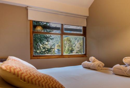 1 dormitorio con cama y ventana en BOG Angostura Apartments en Villa La Angostura