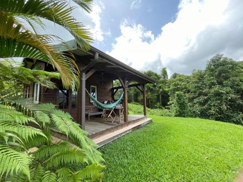 una casa con una hamaca en el porche en Bungalow à flanc de montagne, en Le Morne Rouge