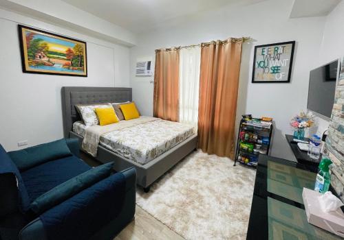 1 dormitorio pequeño con 1 cama y 1 sofá en Gravins616 Condo BCD, en Bacolod