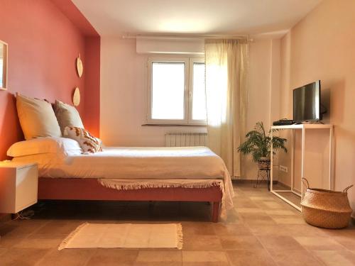 a bedroom with a bed with orange walls and a television at Blue Apricot Apartment con Jacuzzi in Montesilvano