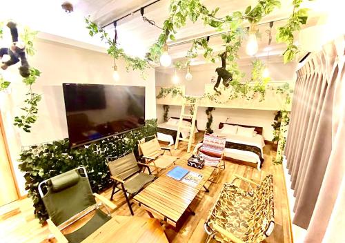 uma sala de estar com uma grande televisão e plantas em Eternity APARTMENT HOTEL 品川 em Tóquio