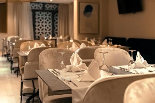 - une salle à manger avec des tables, des chaises et des serviettes dans l'établissement AD HOTEL HYDRA, à Alger