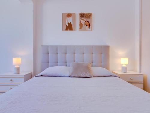 AL - Apartamento Quinta do Romão في كوارتيرا: غرفة نوم بسرير ابيض كبير ومصباحين
