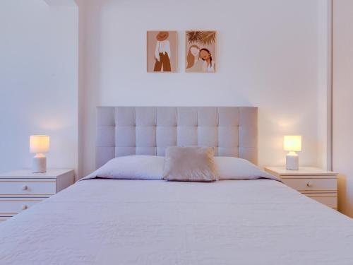 una camera da letto con un grande letto bianco con due lampade di AL - Apartamento Quinta do Romão a Quarteira