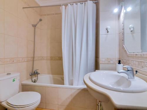 a bathroom with a sink and a toilet and a tub at AL - Apartamento Quinta do Romão in Quarteira