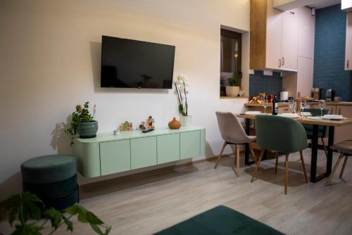 a living room with a table and a tv on a wall at Cross Caraiman View 1 in Buşteni
