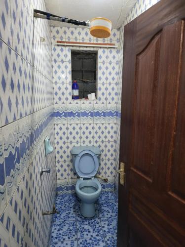 ein Badezimmer mit einem WC mit blauen und weißen Fliesen in der Unterkunft G&G Executive Homes NAKURU in Nakuru