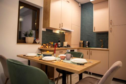 a kitchen with a wooden table and green chairs at Cross Caraiman View 1 in Buşteni