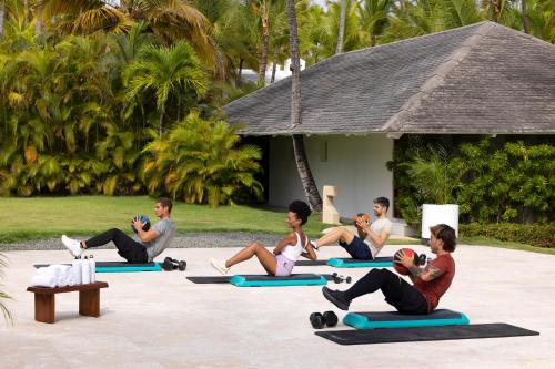 Meliá Punta Cana Beach Wellness Inclusive - Adults only في بونتا كانا: مجموعة من الناس يجلسون في درس اليوغا