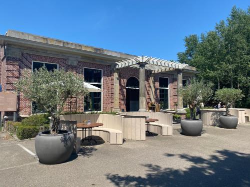 a building with tables and chairs in front of it at Fletcher Landgoedhotel Renesse in Renesse