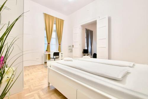 een witte slaapkamer met 2 bedden en een spiegel bij Standard Apartment by Hi5 - Múzeum 5 in Boedapest