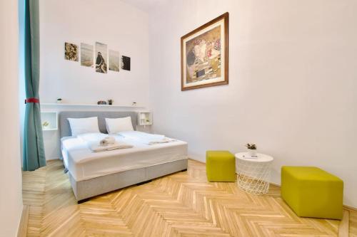 een slaapkamer met een bed en 2 groene stoelen bij Standard Apartment by Hi5 - Múzeum 5 in Boedapest