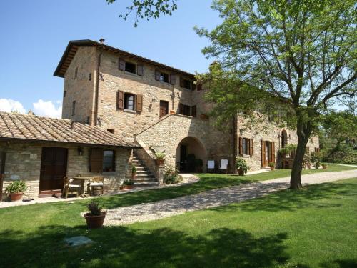 ein großes Steingebäude mit einem Baum im Hof in der Unterkunft Nice apartment with pool and beautiful garden in Montone