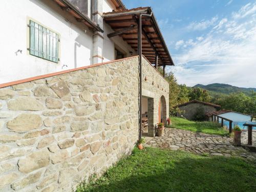 una pared de piedra junto a un edificio en Lovely Holiday Home with private pool, en San Marcello Pistoiese