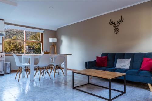a living room with a blue couch and a table at BOG Angostura Apartments in Villa La Angostura