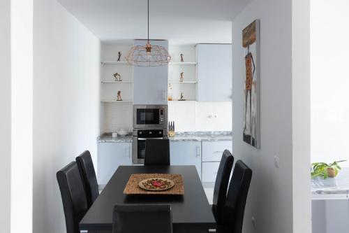 プライアにある2 bdr cozy apt near Praça Center, AC & Fast Wi-Fiのキッチン(ピザ付きのテーブル付)