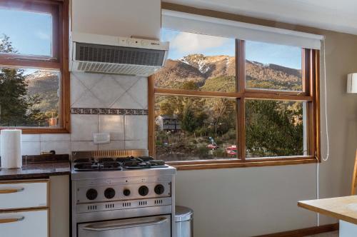a kitchen with a stove and a window with a mountain view at BOG Angostura Apartments in Villa La Angostura