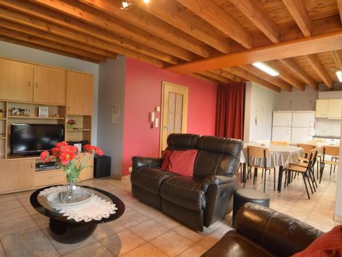 ein Wohnzimmer mit einem Ledersofa und einem Tisch in der Unterkunft Modern Cottage in Baugnez Malmedy with Sauna in Arimont