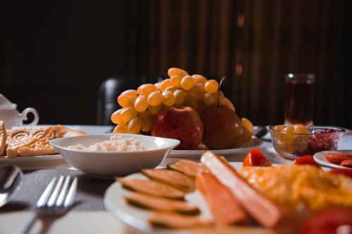 a table topped with plates of food and fruit at Reikartz Kokand in Kokand