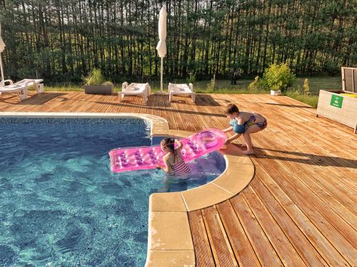 dos niños jugando en una piscina con un juguete en Pensjonat Uroczysko Zaborek, en Janów Podlaski