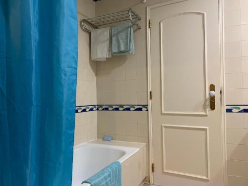 a bathroom with a tub and a white door at Discovery Apartment Vilamoura in Vilamoura