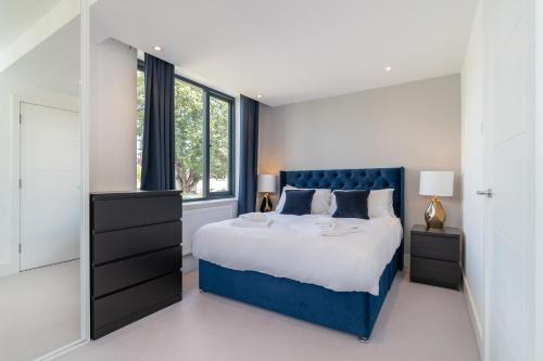 ein Schlafzimmer mit einem blauen Bett und einem Fenster in der Unterkunft 4 Bedrm House Greater London in London