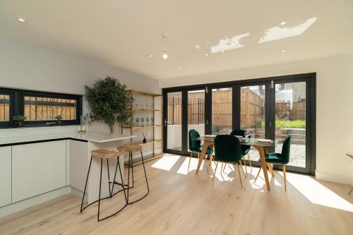 a kitchen and dining room with a table and chairs at 4 Bedrm House Greater London in London