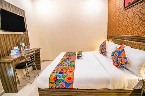 una camera d'albergo con letto e scrivania di FabExpress Orange Suite a Mumbai