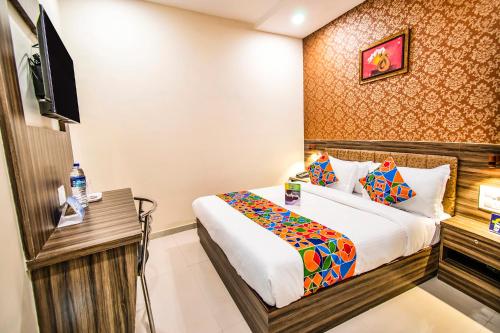 a hotel room with a bed and a television at FabExpress Orange Suites - Nr Mumbai International Airport in Mumbai