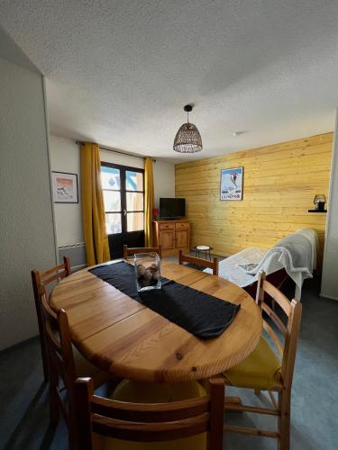 Appartement T2, la Mongie, Bagnères de Bigorre في كامبان: غرفة طعام مع طاولة وكراسي خشبية