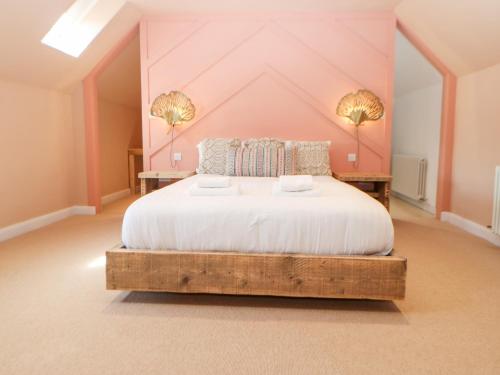 a bedroom with a large bed with a pink wall at The Workshop in Northallerton