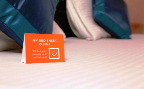a red sign sitting on top of a bed at FabExpress Orange Suites - Nr Mumbai International Airport in Mumbai