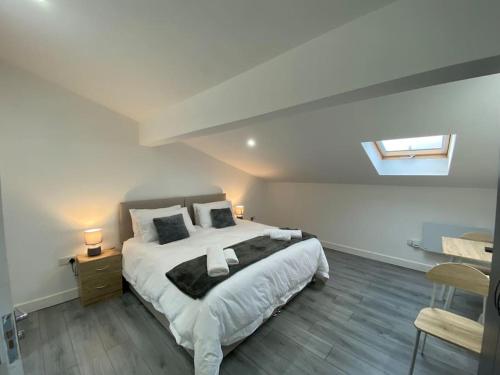 een slaapkamer met een groot bed met witte lakens en kussens bij 221 Soho 2 in Birmingham