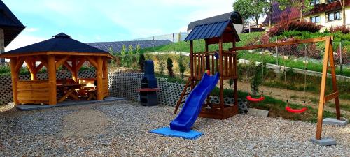 a playground with a blue slide and a gazebo at Hrube DOMKI Zakopane in Zakopane