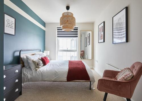 a bedroom with a bed and a chair at The Glassworks by Ritual Stays in Hemel Hempstead