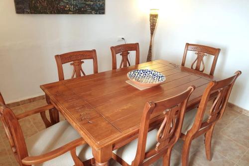 a wooden dining room table with chairs and a bowl on it at Casa Arriba Village House in Zarra in Zarra