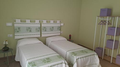 two twin beds in a room with purple boxes at B&B La Chintina in Sant Antonio Di Gallura