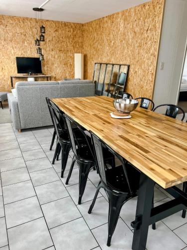 uma sala de jantar com uma mesa de madeira e cadeiras em Appartement confortable et lumineux 60m² em Pluneret