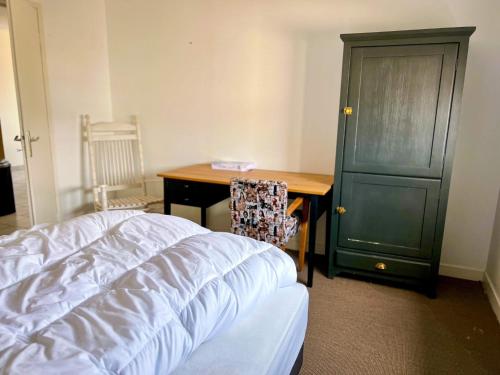 um quarto com uma secretária e um armário verde em Appartement confortable et lumineux 60m² em Pluneret