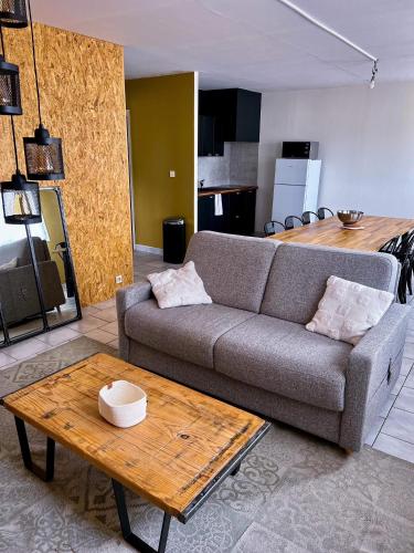 uma sala de estar com um sofá e uma mesa em Appartement confortable et lumineux 60m² em Pluneret