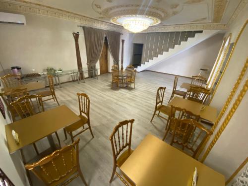 an empty restaurant with wooden tables and chairs at HOTEL UZBEGIM in Urganch