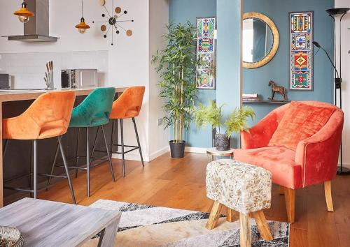 ein Wohnzimmer mit zwei Stühlen und einem Tisch in der Unterkunft The Chapel Cottage by Ritual Stays in Hemel Hempstead