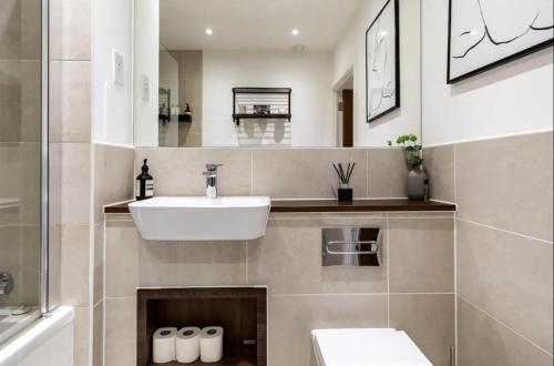 a bathroom with a sink and a mirror at Modern 1 bed l City views l Work Space in London