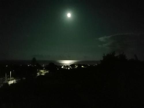 uma lua cheia a subir sobre uma cidade à noite em Quinta das Perdizes - Low Cost em Ponta Delgada