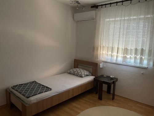 um pequeno quarto com uma cama e uma janela em Sobe kod bolnice Paprikovac em Banja Luka