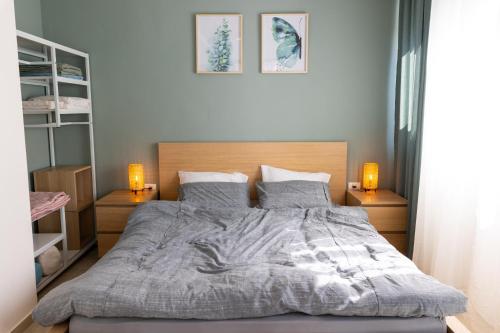 a bedroom with a large bed with two lamps at H-nachala in Tel Aviv