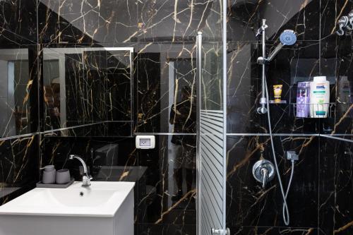 a black bathroom with a sink and a shower at H-nachala in Tel Aviv