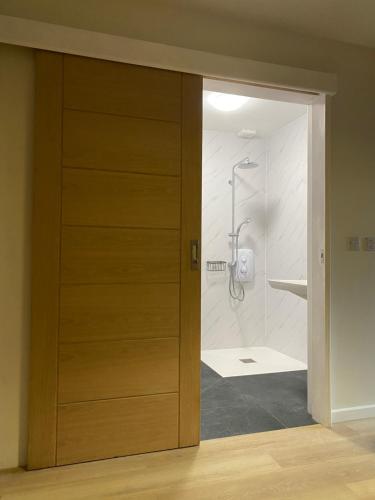 una puerta de madera que conduce a una ducha en el baño en Good Vibes, en Christchurch